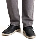 Zapato casual tipo náutico de cuero color azul marino, con cordones y suela de goma en color crema. Presenta costuras reforzadas en la puntera y logo de la marca grabado en el lateral.
