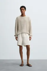 Bermuda relaxed fit confeccionada en tejido ligero de cáñamo. Presenta cintura elástica ajustable con cordón interior, bolsillos laterales y un bolsillo trasero de plastrón con solapa.