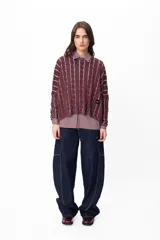 Jean de corte amplio y tiro medio, confeccionado en denim azul oscuro con costuras a contratono en color blanco. Presenta un diseño de pierna curva con bolsillos laterales integrados.