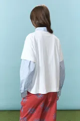 Remera blanca de algodón con estampa frontal colorida de un almacén tradicional. Posee cuello redondo y mangas cortas.