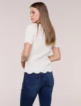 Blusa de punto acanalado color blanco, con escote cuadrado, mangas cortas y terminaciones festonadas en mangas y ruedo.
