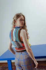 Chaleco tejido a crochet con diseño patchwork multicolor, cuello en V y terminaciones acanaladas en marrón.