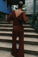 Pantalón palazzo de tiro medio en color marrón, confeccionado en tejido con textura. Cuenta con cintura elástica ajustable mediante cordones y diseño de pierna ancha.