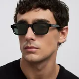 Lentes de sol con montura rectangular de diseño contemporáneo en color verde oliva traslúcido. Presentan cristales oscuros con protección UV.