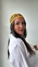 Gorro mostaza de crochet con diseño de red.