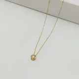 Conjunto de collar y aros de oro amarillo 18k con dije de circonia engarzada. El collar tiene una cadena fina de 45cm de largo.