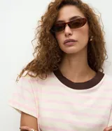 Blusa de corte boxy confeccionada en algodón, con diseño de rayas horizontales, cuello redondo de punto en color contrastante y mangas cortas.