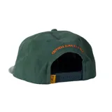 Gorra verde con visera curva y parche frontal amarillo con el logo "TCSS" en naranja y una palmera, y el texto "CRITICAL SLIDE X LA ISLA".