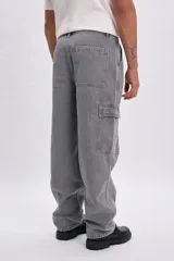 Pantalón de jean cargo recto color gris claro, de tiro medio, con bolsillos laterales con solapa en las piernas.