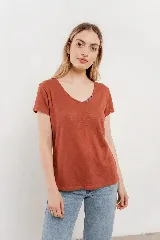 Remera de lino color verde lima, con escote redondo y detalle de cuatro botones decorativos en el lateral del escote.