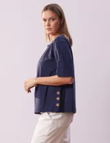 Blusa de algodón azul marino, de manga corta amplia, con tajo en el ruedo lateral decorado con botones.