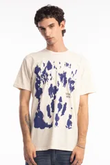 Remera de algodón color beige con estampado abstracto en azul marino y texto pequeño en el frente.