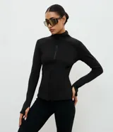 Campera deportiva Get Over de ajuste entallado, confeccionada en microfibra con malla térmica. Presenta cuello alto, cierre frontal con cremallera, mangas largas con orificio para pulgar y bolsillos laterales con cierre.
