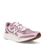 Championes de running New Balance modelo Fresh Foam Arishi v4, color rosado con detalles en blanco. Presentan una parte superior de malla transpirable con refuerzos sintéticos, logo lateral característico y entresuela con tecnología Fresh Foam para mayor amortiguación.