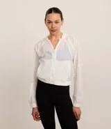 Campera rompevientos deportiva blanca, confeccionada en poliamida, con capucha, cierre delantero en cremallera, tirador gomoso y puños ajustados.