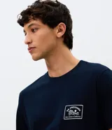 Remera de algodón color azul marino, con cuello redondo, mangas cortas y estampa frontal pequeña con ilustración de montaña y texto No Pressure.