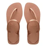 Sandalias tipo ojotas Havaianas modelo Flash Urban, con diseño de tiras cruzadas que incluyen una sujeción trasera en el talón. Presentan una textura granulada en la plantilla y acabado metalizado.