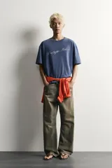 Remera boxy fit azul con efecto lavado, cuello redondo y manga corta, con estampa en el pecho.