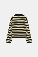 Polo de manga larga confeccionado en algodón, con diseño a rayas horizontales en tonos amarillos, verdes y oscuros. Presenta cuello solapa, cierre frontal con botones y bajo recto.