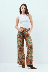Jean wide leg de tiro alto en denim 100% algodón con estampado floral en tonos naranjas, amarillos y verdes.