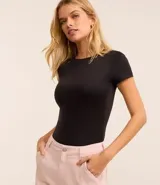 Body de cuello redondo y manga corta, confeccionado en tejido de poliamida con elastano. Presenta un diseño liso y ajustado al cuerpo con cierre en la entrepierna.