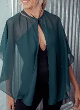 Capa corta color fucsia de gasa, estilo torerita, con mangas amplias y abertura frontal.