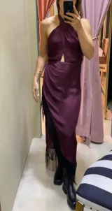 Vestido largo de seda lavada color bordó, con escote halter cruzado, abertura frontal en el pecho y falda con capas y flecos laterales.