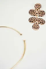 Set de collar y aros dorados con dije de flor con estampado animal print. El collar es tipo choker y los aros son colgantes.