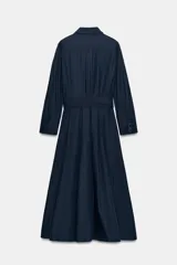 Vestido midi de estilo camisero color bordó, con cuello solapa, escote en pico y cierre frontal con botones ocultos. Presenta manga larga, bolsillos laterales ocultos, solapas decorativas en el pecho y cinturón de lazada en el mismo tejido.