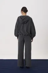 Campera con capucha y cierre frontal, confeccionada en tejido de punto con efecto lavado. Presenta mangas largas con puños ajustados y un corte relajado.