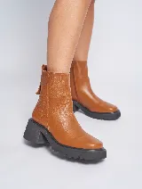 Bota corta de cuero color marrón con suela track y cierre lateral.