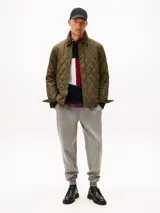 Pantalón de jogging gris melange, confeccionado en mezcla de algodón y poliéster, con corte regular y pierna cónica. Presenta cintura con cordón, bolsillos laterales y un bolsillo trasero de ojal.