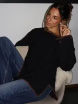 Sweater tejido de punto jersey en color negro, con terminaciones hechas a mano en crochet a contratono con detalles de lurex. Presenta una silueta oversize, mangas acampanadas y cuello a la base.