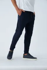 Pantalón de jogging gris melange, de felpa, con puños y bolsillos con cierre.