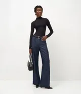 Blusa de encaje negro con cuello alto y mangas largas, de corte ajustado y diseño con transparencias.