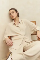 Camisa beige de manga larga con botones a tono.