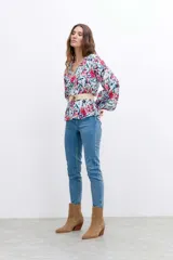 Blusa estampada con flores rojas, verdes y azules, escote en V y mangas balloon.