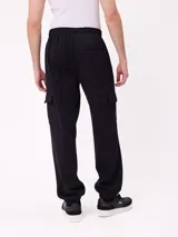 Babucha de estilo cargo en color negro, confeccionada en tejido de algodón y poliéster. Presenta cintura elástica con cordón ajustable, bolsillos laterales tipo cargo y puños elásticos en los tobillos.