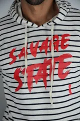 Hoodie de algodón con estampado a rayas horizontales finas en color negro sobre fondo blanco. Presenta capucha con cordones ajustables y estampa frontal con el texto 'SAVAGE STATE' en color rojo, junto a un pequeño logo de un pájaro en la parte inferior derecha.
