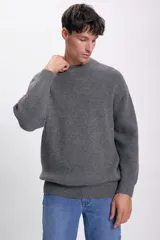 Sweater gris de punto con cuello redondo y mangas largas.