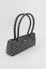 Cartera tipo baguette color negro con textura efecto cocodrilo, diseño alargado, doble asa de mano y cierre superior.