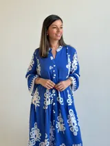 Vestido largo color azul con estampado ornamental en color blanco, escote en V con botones frontales y mangas tres cuartos con volados.