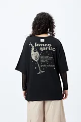 Remera color beige con cuello redondo y mangas cortas. Estampado pequeño en el frente con la frase "Spritz and Shine".