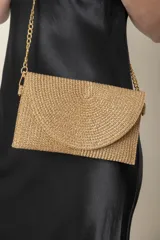 Sobre de fiesta dorado con textura de lurex y cadena dorada para colgar.