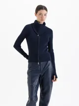 Cardigan de tejido de punto fino color azul marino, con silueta ajustada al cuerpo, cuello alto y cierre frontal de doble camino.