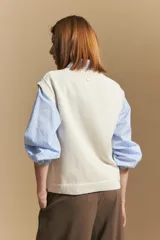 Chaleco tejido color crema con diseño de rombos calados, cuello redondo y sisas.