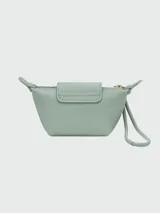 Monedero Longchamp de la línea Le Pliage Xtra, confeccionado en cuero color verde menta. Presenta una solapa con botón a presión metálico dorado grabado con el logo de la marca y un tirador de cierre circular con el icónico caballo de Longchamp.