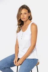 Musculosa blanca sin mangas, de corte clásico y calce cómodo, confeccionada en tejido suave. Presenta escote redondo, cartera con botones frontales y un pequeño bolsillo aplicado en el pecho.
