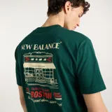 Remera New Balance de hombre, color verde oscuro, de manga corta y cuello redondo, con pequeño estampado gráfico en el pecho.
