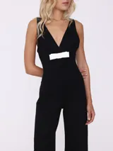 Mono largo negro con escote en V y detalle de lazo blanco en la cintura.